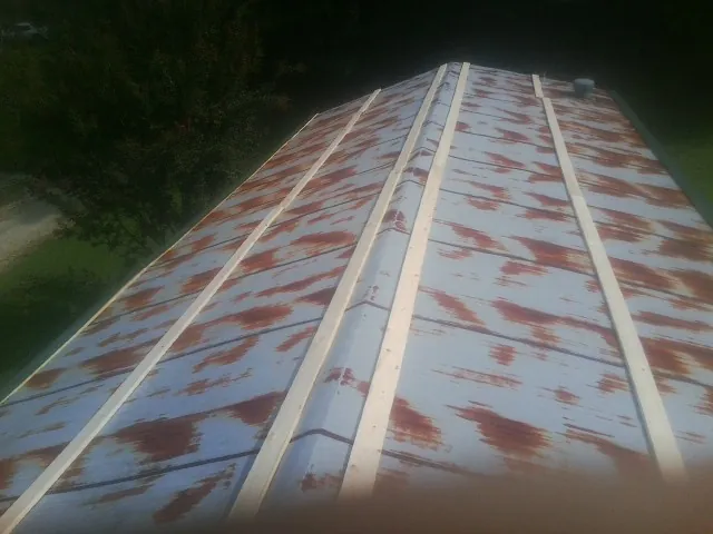 Rusted metal roof panels with new wood purlins before replacement — Storm Damage Roof Repair in Lowden by Roofing Brothers