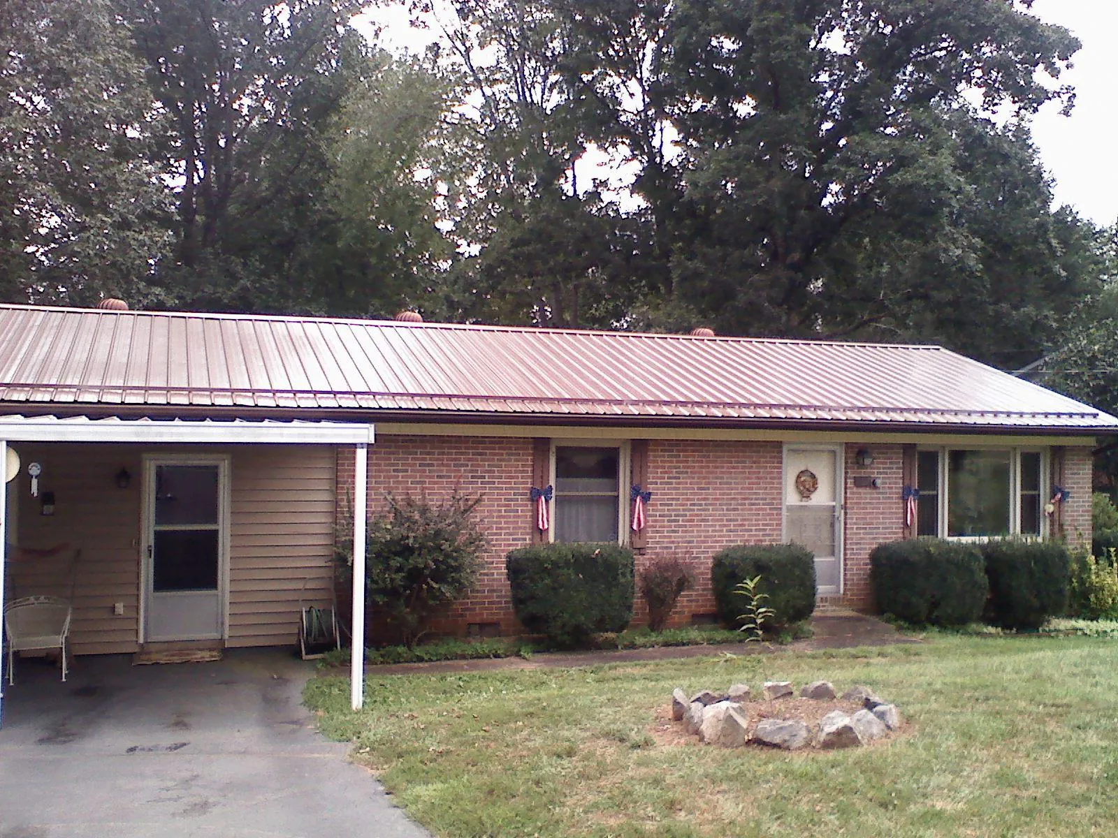 Bronze metal roof and carport on a brick ranch home — Roof Repair work by our crew in Lowden